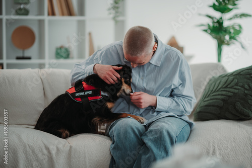 Fotografía Person petting emotional support dog on couch