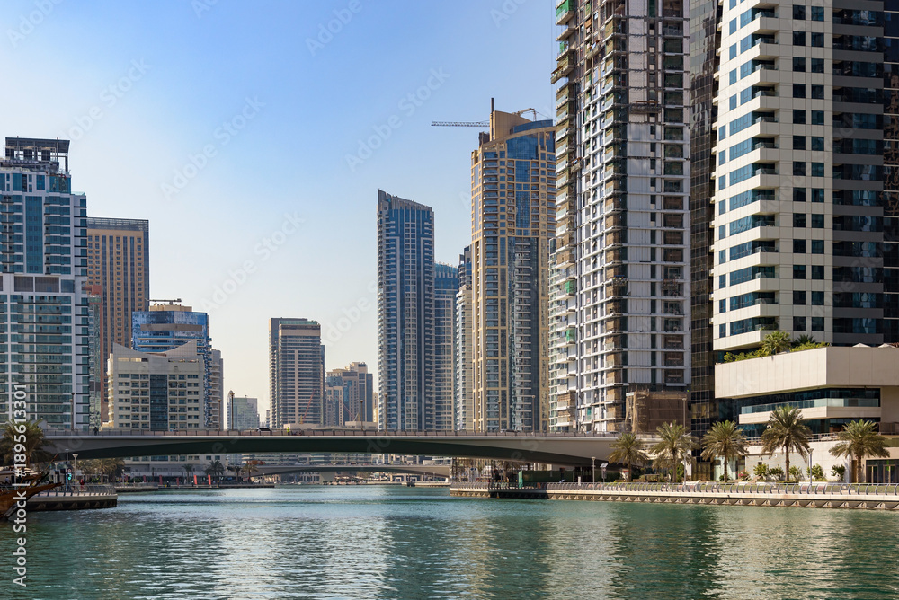 Fototapeta premium Modern skyscrapers and a road bridge crossing the Dubai Marina canal