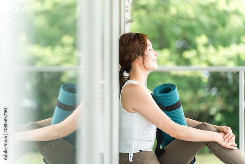 Female yoga instructor holding a yoga mat, women doing yoga and pilates
