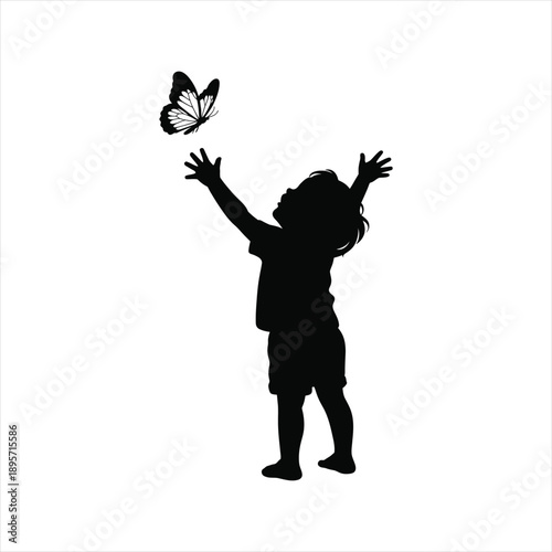 Happy child silhouette playing with a butterfly reaching hands towards the sky