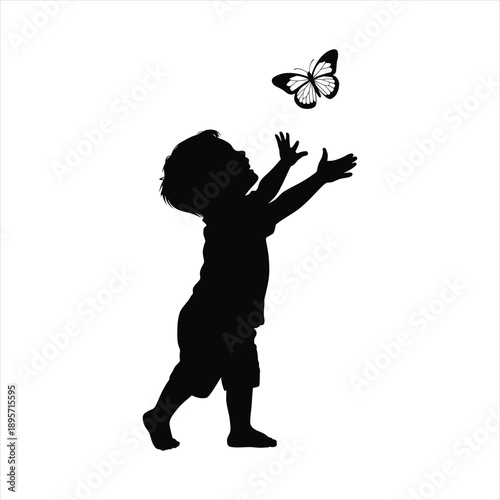 Little boy silhouette reaching up to catch a flying butterfly concept of childhood wonder