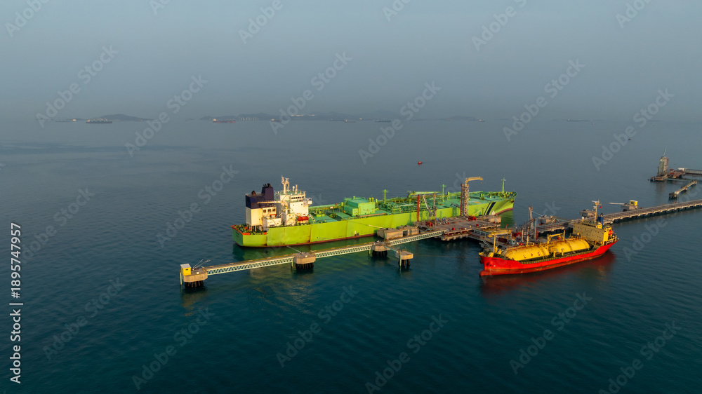 Fototapeta premium Aerial view LPG tanker ship at oil and gas terminal platform, Liquefied Petroleum Gas tanker ship industrial oil gas terminal tanker ship, LPG tanker ship loading and unloading petrochemical industry.