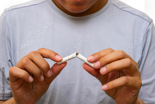 Photos Breaking cigarette in hand – symbol of quitting smoking, promoting lung health, cancer prevention, and freedom from tobacco addiction