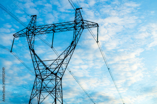 Metal power line pylon against blue sky, electricity transmission structure