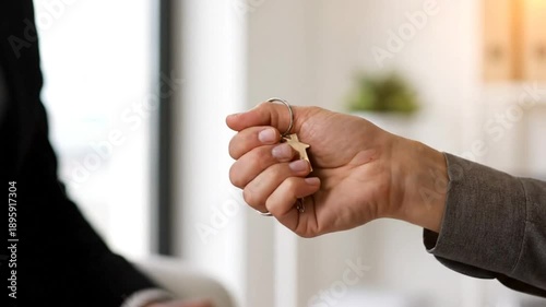 Real estate handover of keys from seller to buyer in office setting showing transaction