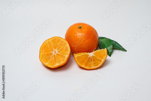 Fresh orange fruit with slices on isolated white background.