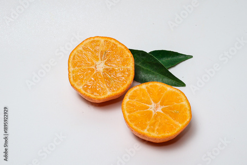 Fresh orange fruit with slices on isolated white background.