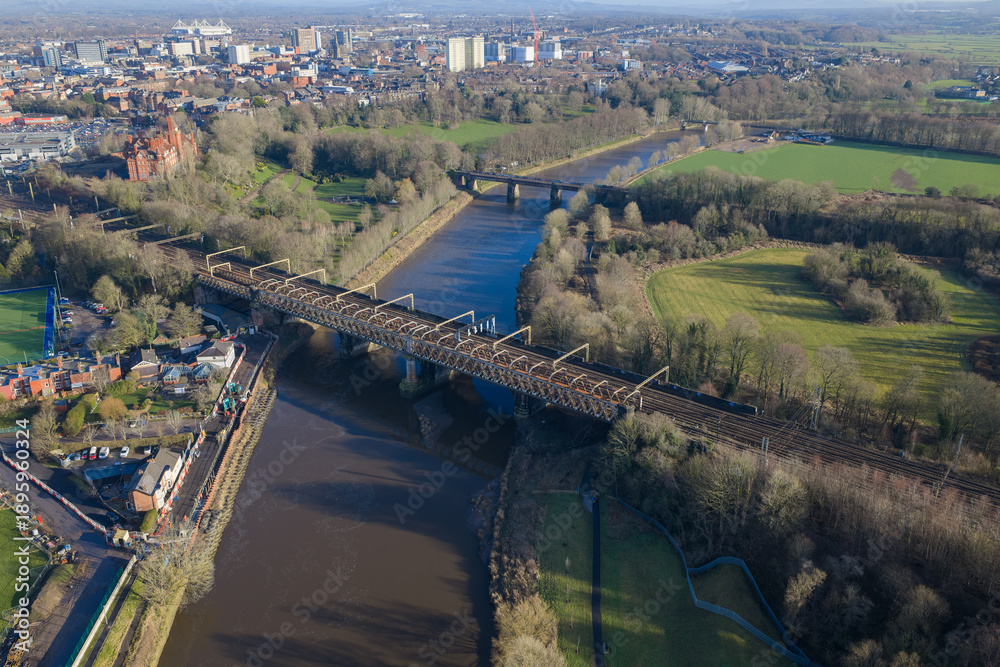Fototapeta premium Aerial image of the River Ribble featuring the West Coast Main Line viaduct and the green expanse of Avenham Park in Lancashire.