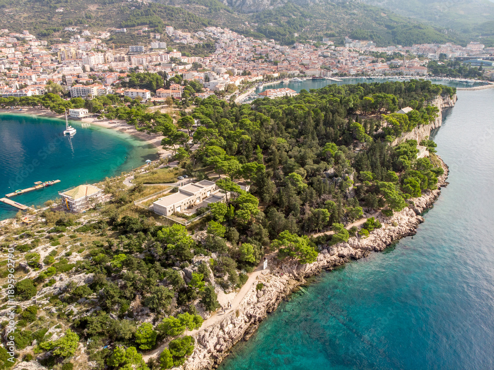 Fototapeta premium Croatia's Adriatic coast on the Makarska Riviera, aerial view. The bay and beautiful Biokovo Mountains, a summer resort, are seen from a drone.