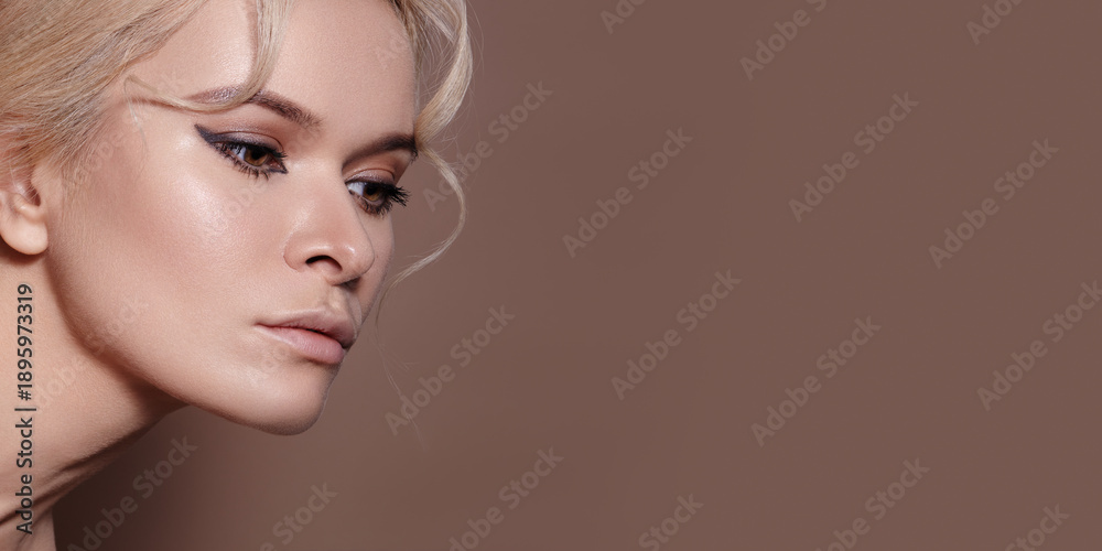Obraz premium High Glam White Model Dewy Skin Rendered With Luminous Highlight, Sharp Eyeliner Wing, Sculpted Cheekbones, Flawless Finish, Neutral Brown Backdrop, Beauty Editorial Mood, Influencer Ready Look
