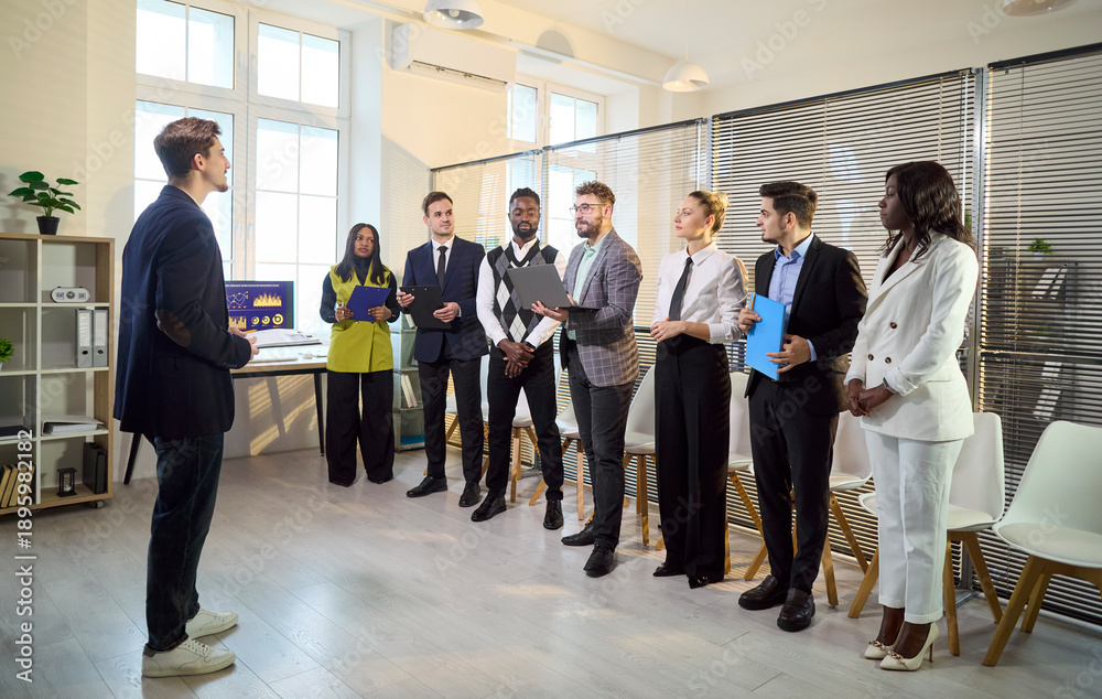 Fototapeta premium Business team meeting with training coach leader. In a modern office, diversity guides a group preparing for seminar and presentation practice. Clear leadership and strong teamwork concept.