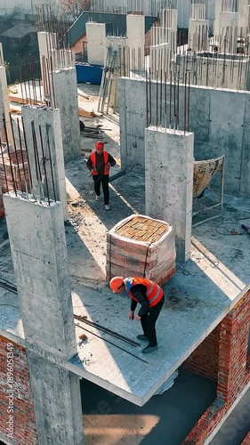 Aerial view Construction works. Builders are building another floor of a multi-story brick building.