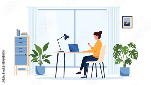 Young woman working from home on her laptop at a modern desk in a comfortable room with houseplants and a large window in the background.