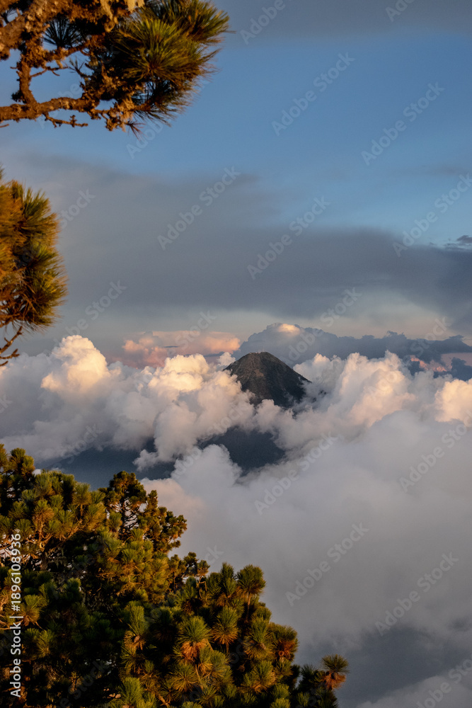 Fototapeta premium Hikers rewarded with a spectacular sunset from Acatenango volcano as golden light washes over the rugged peaks of Central America