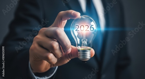 Future business vision 06 concept, Closeup Businessman Hand holding glowing light bulb with year 06, symbolizing innovation, new ideas, and long term strategic goals.