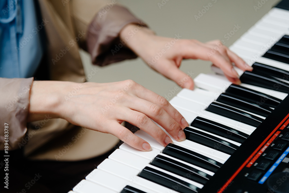 Obraz premium female pianist hands on black and white synthesizer keyboard, close-up view, young woman playing piano, professional musician