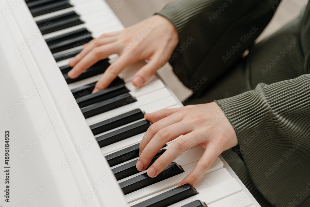 Obraz premium female pianist hands on black and white synthesizer keyboard, close-up view, young woman playing piano, professional musician