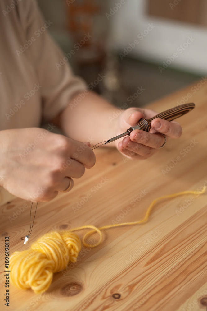 Obraz premium The seamstress threads the thread into a large sewing needle