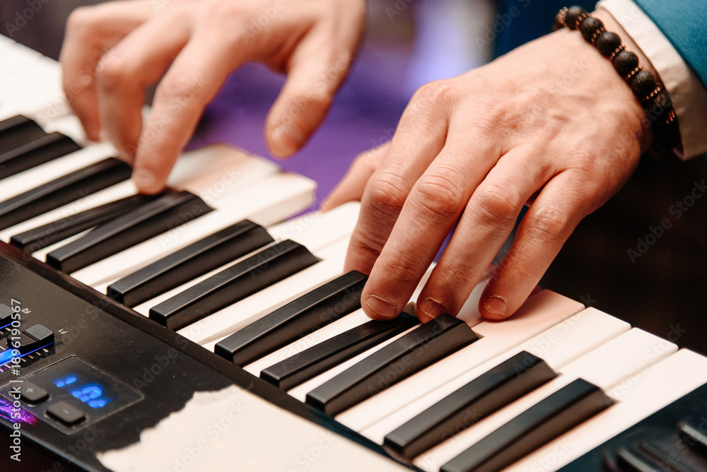 Obraz premium male pianist hands on black and white piano keyboard, close-up view, young man playing piano, professional musician
