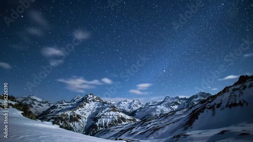 Night sky over snowy mountain peaks illuminated by starlight