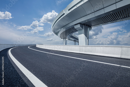 Bilde på lerret An empty asphalt road and a modern overpass under a clear blue sky on a sunny da