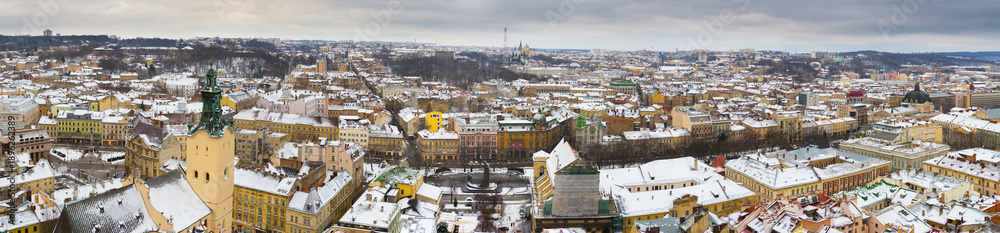Obraz premium Lviv, Ukraine, Western Europe panoramic winter cityscape from Town Hall tower, Latin Cathedral and Opera House architecture with snowy rooftops on Svobody Avenue under gray sky, urban tourism.