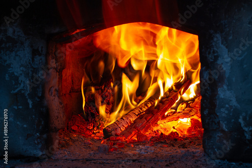 Firewood is burning hot in the old stone hearth