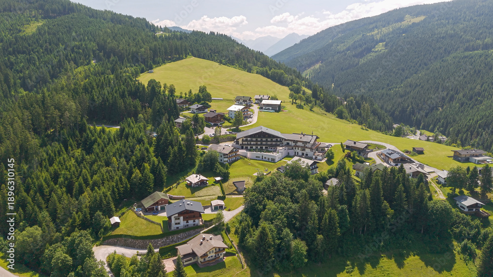 Obraz premium Fly with me across the little Austrian village of Filzmoos which is embedded into juicy grass and the Dachstein mountain chain which is a pure magnet of tourists all over the year seasons