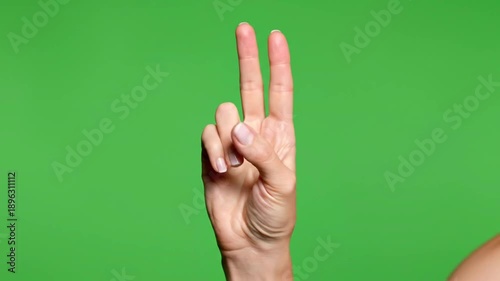 Hand gestures showing fingers against a green screen background