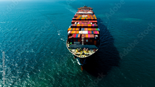Aerial front view of cargo container ship sailing forward in deep sea for global business logistics and international commercial maritime import export transportation.