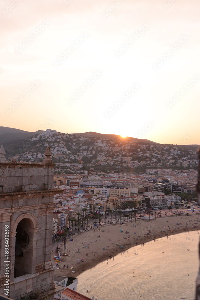 Fototapeta premium View from a stone wall of a city by the sea at sunset