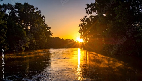 Glistening river at sunrise, framed by lush trees casting shadows in warm golden sunlight