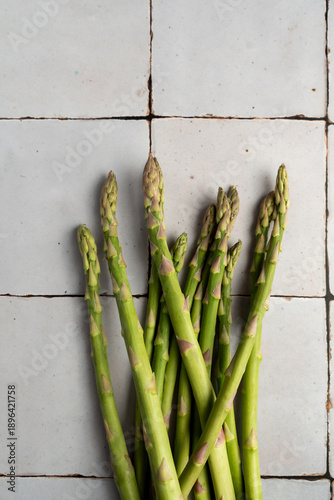 Green asparagus bundle photographed from above with clean and minimal aesthetic. Seasonal vegetables presented as raw food ingredients, suitable for healthy eating, spring produce and food background.