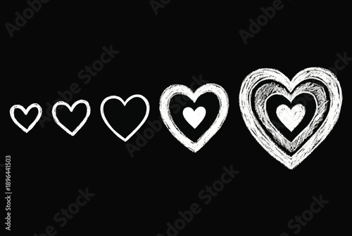 A set of white chalk hearts on a black background, symbolizing love and affection.