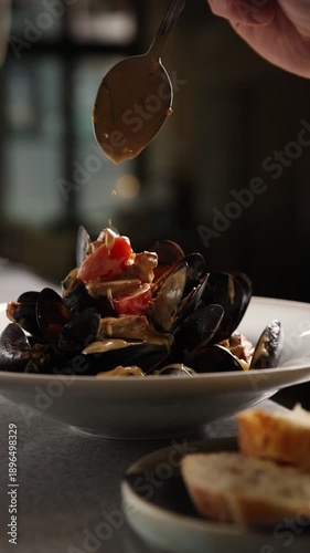 The chef prepares mussels in the kitchen.