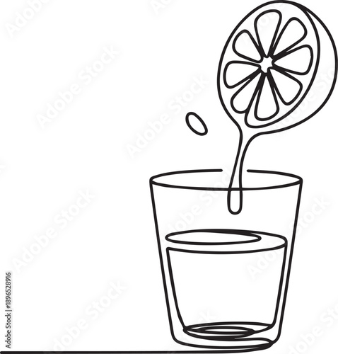 Lemon slice being squeezed into a glass of water from above viewpoint