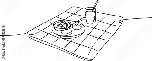 A breakfast scene with plate, utensils, and glass on a tablecloth viewed from above