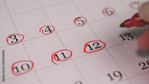 Hand Circling Consecutive Dates On Calendar To Mark Recurring Sessions, CloseUp Rows Of Red Rings, Planning For Workshop Series Or Course Schedule, Organized And Methodical Tone
