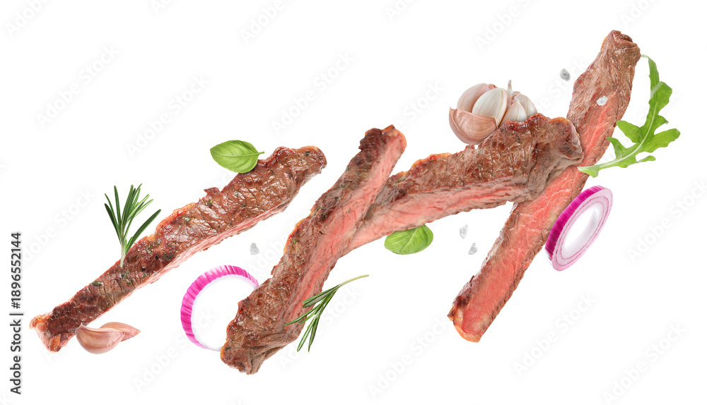 Fototapeta premium Roasted beef pieces, herbs, onion and garlic flying in air on white background