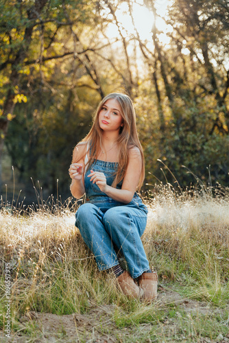 Girl sitting in sunlit field