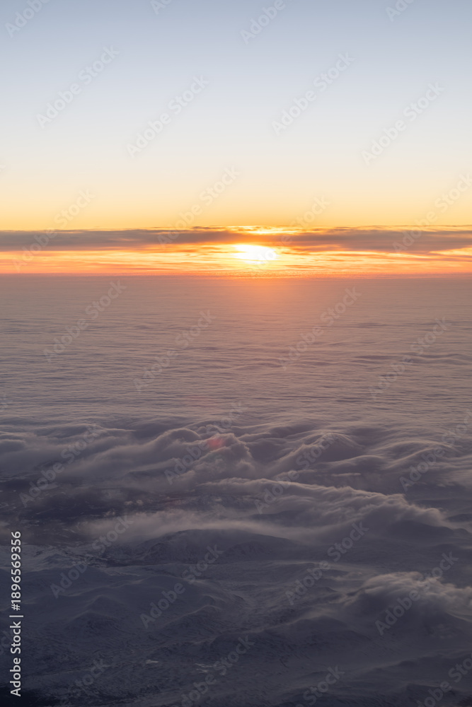 Fototapeta premium Golden sun creating light over clouds and mountains