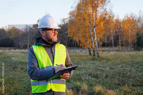 Billede på lærred Matured male professional working on a vacant field, a new construction site