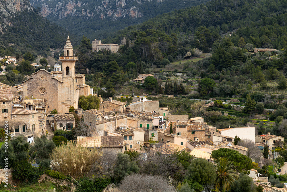 Obraz premium Panoramic view of the mountain village of Valldemossa with church Sant Bartomeu in Serra de Tramuntana mountains, Mallorca, Balearic Islands, Spain
