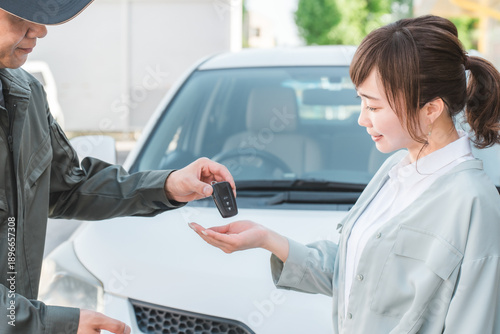 Photos Male auto mechanic staff handing over car keys to female customer