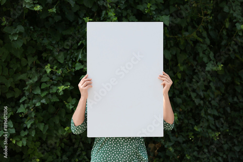 Young woman holding blank p...