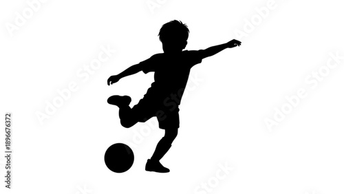 Silhouette of a Young Boy Kicking a Soccer Ball