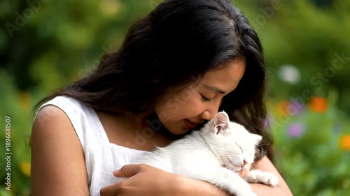 Woman Holding White Cat in Garden.