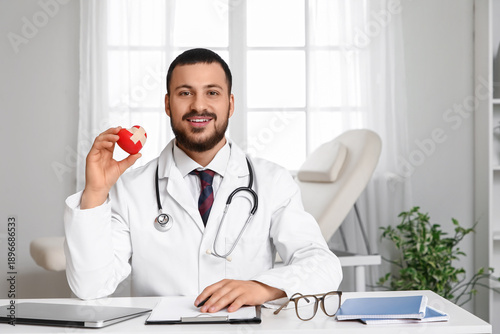 Young happy male doctor hol...
