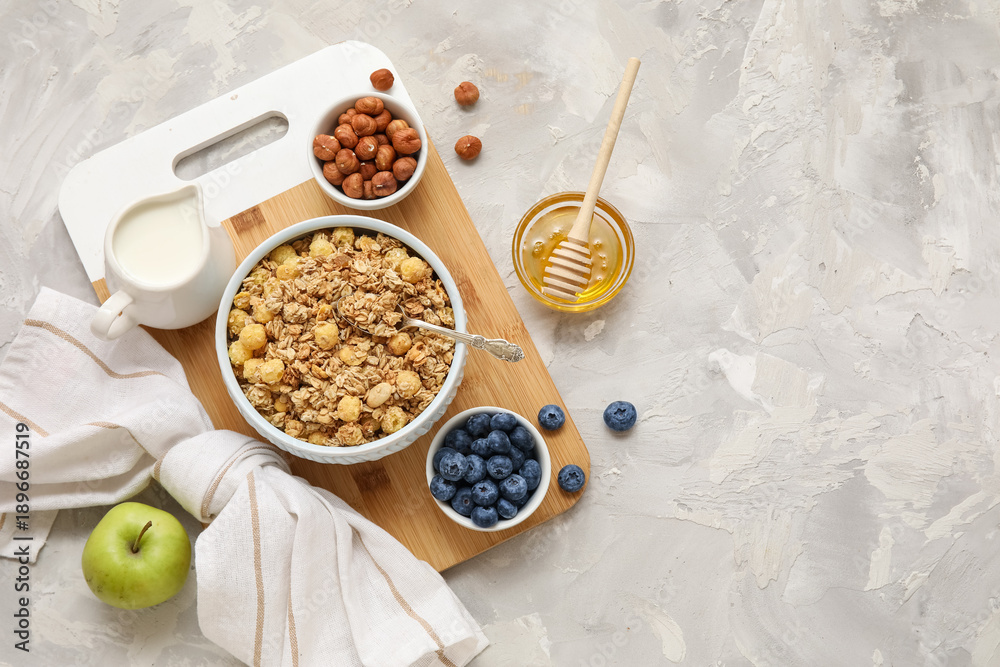 Fototapeta premium Bowls with tasty granola and ingredients on grey grunge background