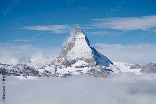 Landscape view of Matterhorn peak mountain in Switzerland cover with snow and clouded blue sky